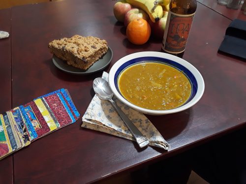 A bowl of curried butternut squash, red lentil and apple soup served with soda bread and a local IPA. Hal's copy of his deck is fanned out on the table.