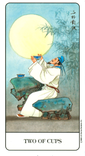 The Two of Cups from the Chinese Tarot. In this image, a holy man seated on a boulder lifts an offering bowl to the full moon behind and slightly above him. A second bowl sits on a larger boulder next to him, while graceful bamboo sways in the background. 