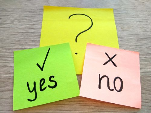 A yellow sticky with a question mark, below which is a green sticky with a check mark and the word "yes" then a pink sticky with an X and the word "no."